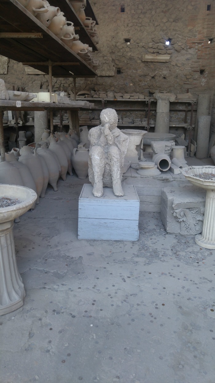 Plaster cast of man covering his face in Pompeii